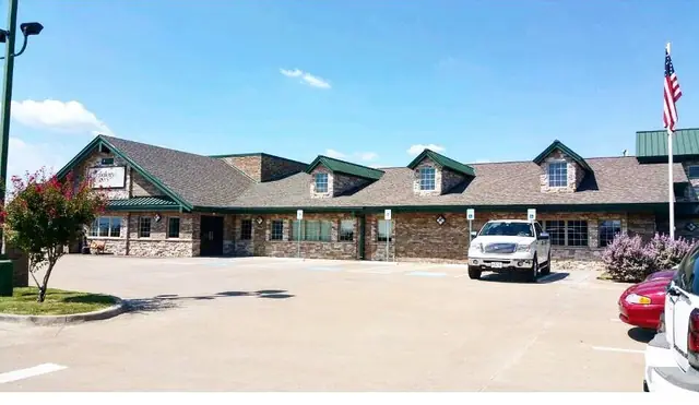 Completed commercial building with stone elevation and standing-seam roof accents