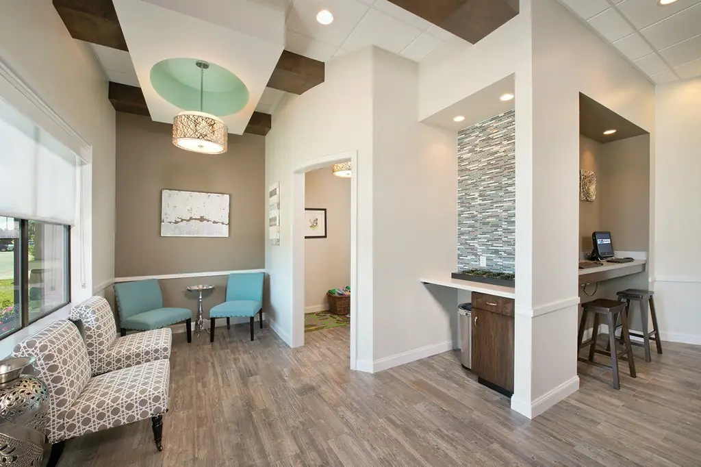 Finished commercial waiting room with exposed stained beams and a tile feature wall, a completed build-out by MAG Builders