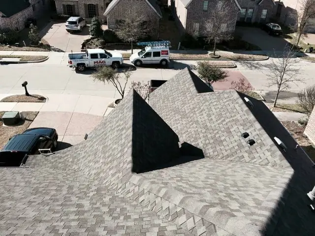 Aerial view of a completed MAG Builders re-roof with the company pickup parked at the kerb
